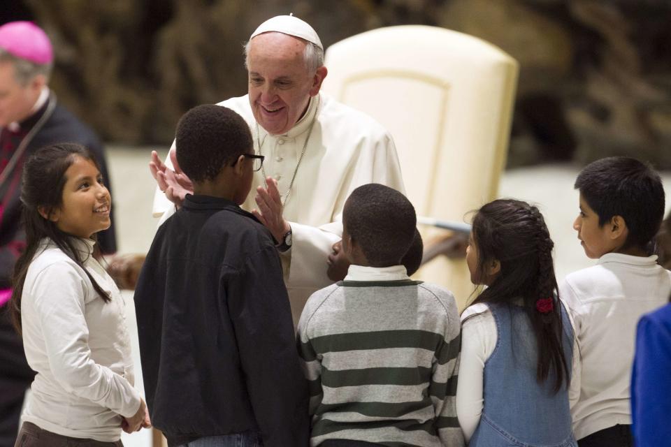 Pope Francis greets children assisted by volunteers of Santa Marta institute during an audience in the Vatican