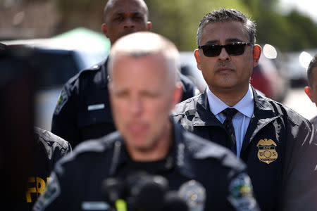 An ATF agent watches as police chief Brian Manley speaks during a news conference near the scene where a woman was injured in a package bomb explosion in Austin, Texas, U.S., March 12, 2018. REUTERS/Sergio Flores