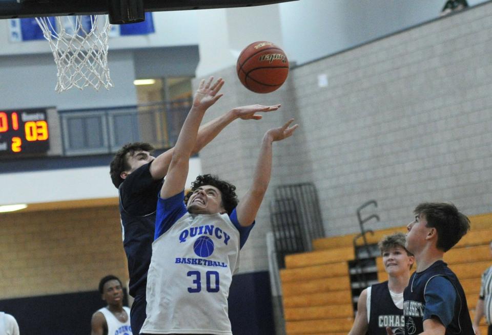 Cohasset's Sam Larsen, left, knocks away the shot of Quincy's Jesus Vega Ramos, center, during a boys basketball preseason scrimmage at Quincy High School, Thursday, Dec. 7, 2023.