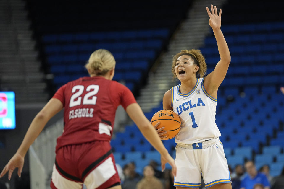 UCLA guard Kiki Rice, right, gestures to teammates as Cal State Northridge guard Kaitlyn Elsholz defends during the first half of an NCAA college basketball game Thursday, Dec. 7, 2023, in Los Angeles. (AP Photo/Mark J. Terrill)