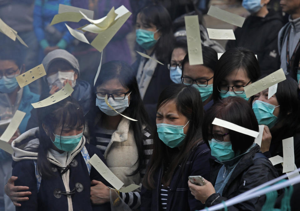 <p>Relatives throw paper money as they pay last tributes to bus crash victims in Hong Kong, Feb. 11, 2018. (Photo: Vincent Yu/AP) </p>