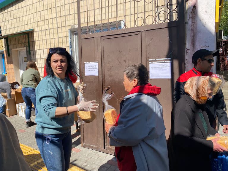 La gente espera por las mañanas para recibir un paquete de pan