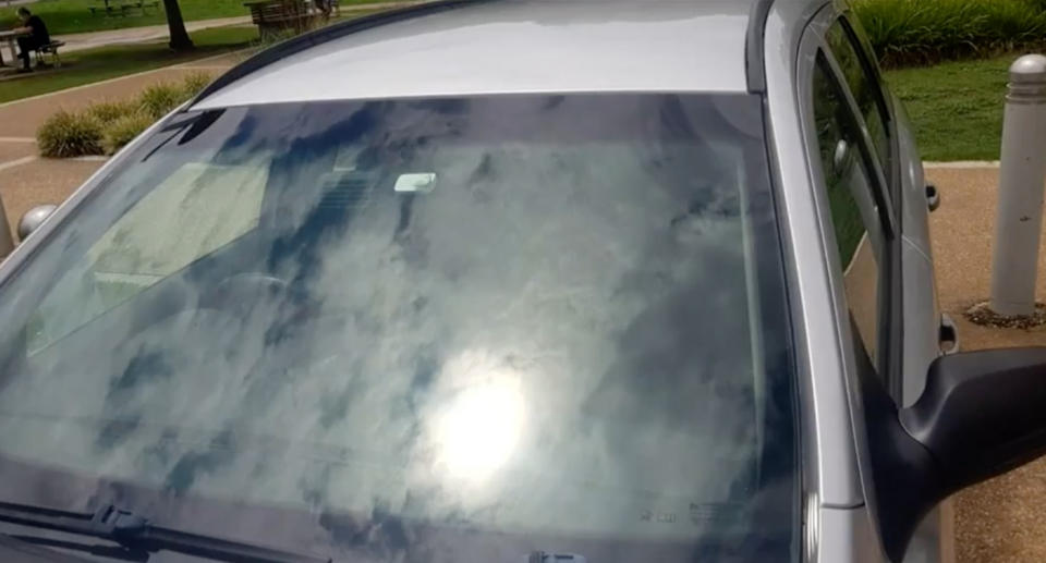 A photo of Ms Coral's car taken by the parking inspector with the sun shining off the windshield.