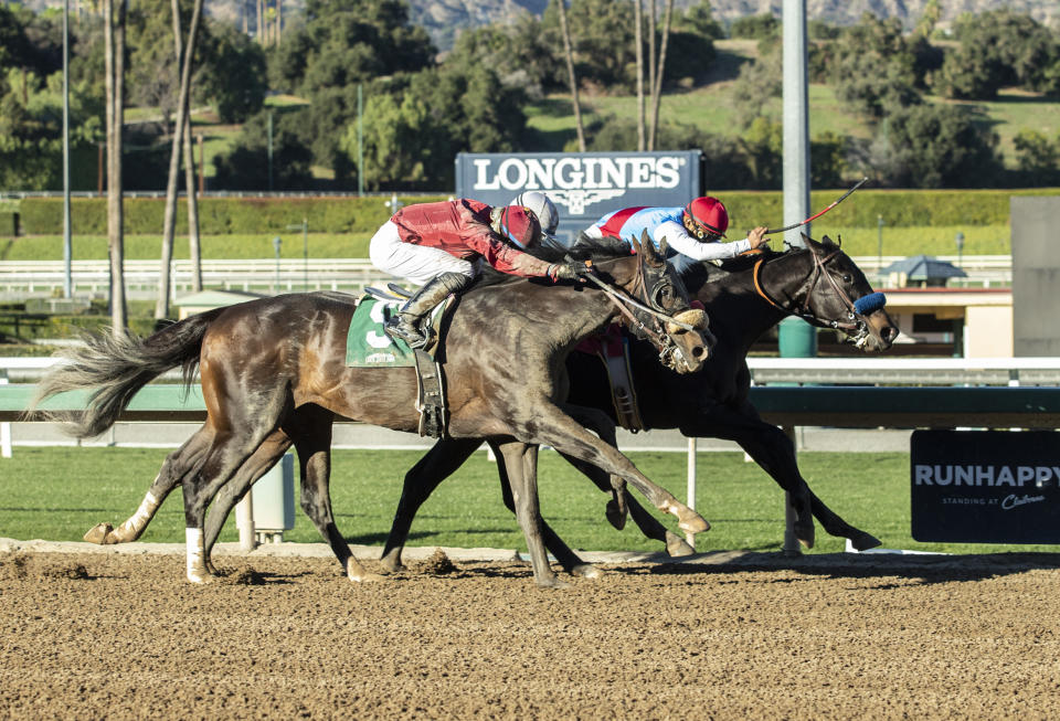 In a photo provided by Benoit Photo, Medina Spirit and jockey Abel Cedillo, inside, hold off Roman Centurian, outside, with Juan Hernandez, and Hot Rod Charlie, middle, with Joel Rosario, to win the Grade III, $100,000 Robert B. Lewis Stakes horse race Saturday, Jan. 30, 2021, at Santa Anita in Arcadia, Calif. (Benoit Photo via AP)