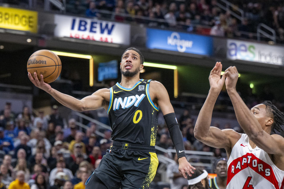 Indiana Pacers guard Tyrese Haliburton (0) shoots while defended by Toronto Raptors forward Scottie Barnes (4) during the first half of an NBA basketball game in Indianapolis, Monday, Feb. 26, 2024. (AP Photo/Doug McSchooler)