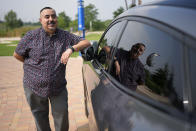 Jose Valdez, 45, who owns three EVs, poses with his Mustang Mach-E, Thursday, May 9, 2024, in San Antonio. Many Americans still aren’t sold on going electric for their next car purchase. High prices and a lack of easy-to-find charging stations are major sticking points, a new poll shows. Valdez owns three EVs, including a new Mustang Mach-E. With a tax credit and other incentives, the sleek new car cost about $49,000, Valdez said. He thinks it's well worth the money. (AP Photo/Eric Gay)