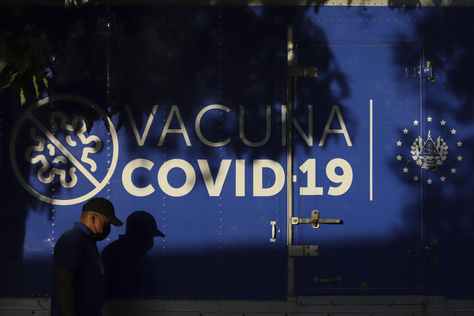 A driver walks past a refrigerated container truck from the Health Ministry that will transport doses of COVID-19 vaccines which El Salvador's government is donating and delivering to neighboring Honduras, shortly before departing San Salvador, El Salvador, Thursday, May 13, 2021. (AP Photo/Salvador Melendez)