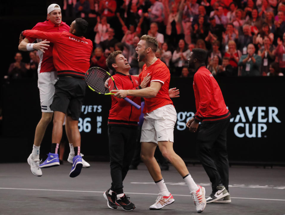 Team World's, from left, John Isner, Nick Kyrgios, Diego Schwartzman, Jack Sock, and Frances Tiafoe celebrate the team's win over Team Europe's Roger Federer and Alexander Zverev with teammate in a men's doubles tennis match at the Laver Cup, Sunday, Sept. 23, 2018, in Chicago. (AP Photo/Jim Young)