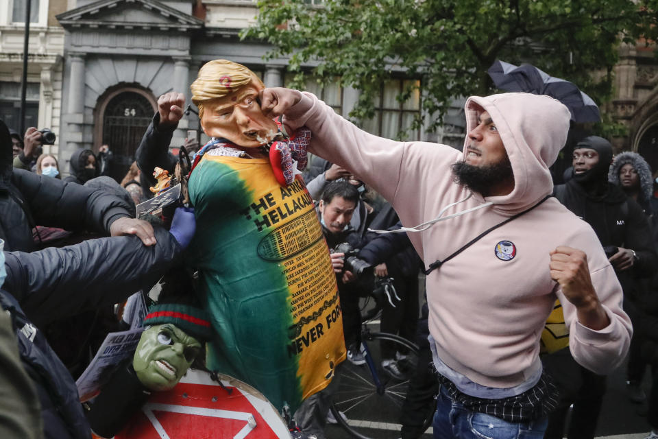 A demonstrator punches a puppet depicting US President Donald Trump during a Black Lives Matter march in London, Saturday, June 6, 2020, as people protest against the killing of George Floyd by police officers in Minneapolis, USA. Floyd, a black man, died after he was restrained by Minneapolis police while in custody on May 25 in Minnesota. (AP Photo/Frank Augstein)