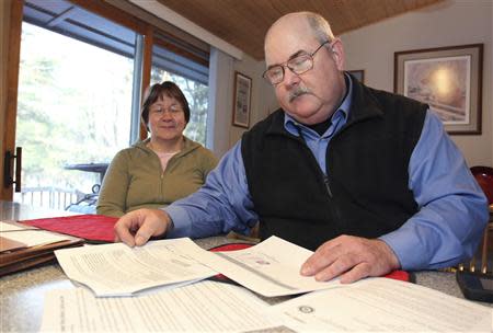 Retired Wisconsin State Trooper Keith Young and his wife Michelle look at paper work at their home in Elk Mound, Wisconsin March 22, 2014. REUTERS/Andy Clayton-King