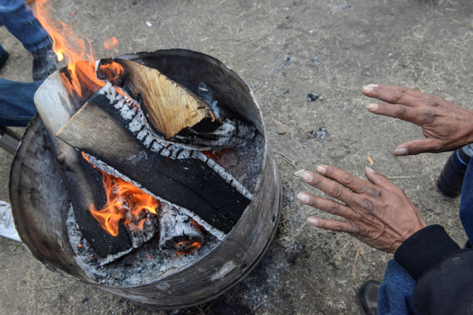 <p>A man warms his hands by the fire in the Oceti Sakowin camp during a protest against the Dakota Access pipeline near the Standing Rock Indian Reservation near Cannon Ball, North Dakota, U.S. November 11, 2016. (Photo: Stephanie Keith/Reuters) </p>