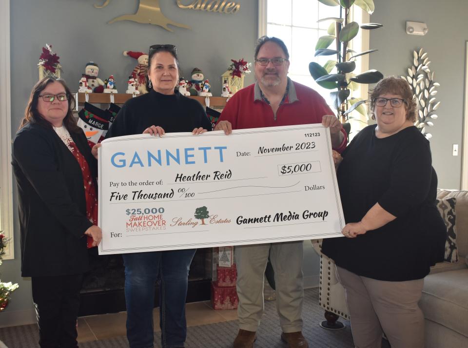 Adrian's Heather Reid, second from left, was one of among three winners in Gannett's Fall Home Makeover Sweepstakes, a national contest. Reid won $5,000 in the sweepstakes and was presented with a giant check last week. She is pictured holding the check along with Alice Comfort, left, assistant manager at Sterling Estates in Adrian, Scott DeVore, property manager, and Kim Haller, senior account executive with LocaliQ, Gannett’s online marketing company.