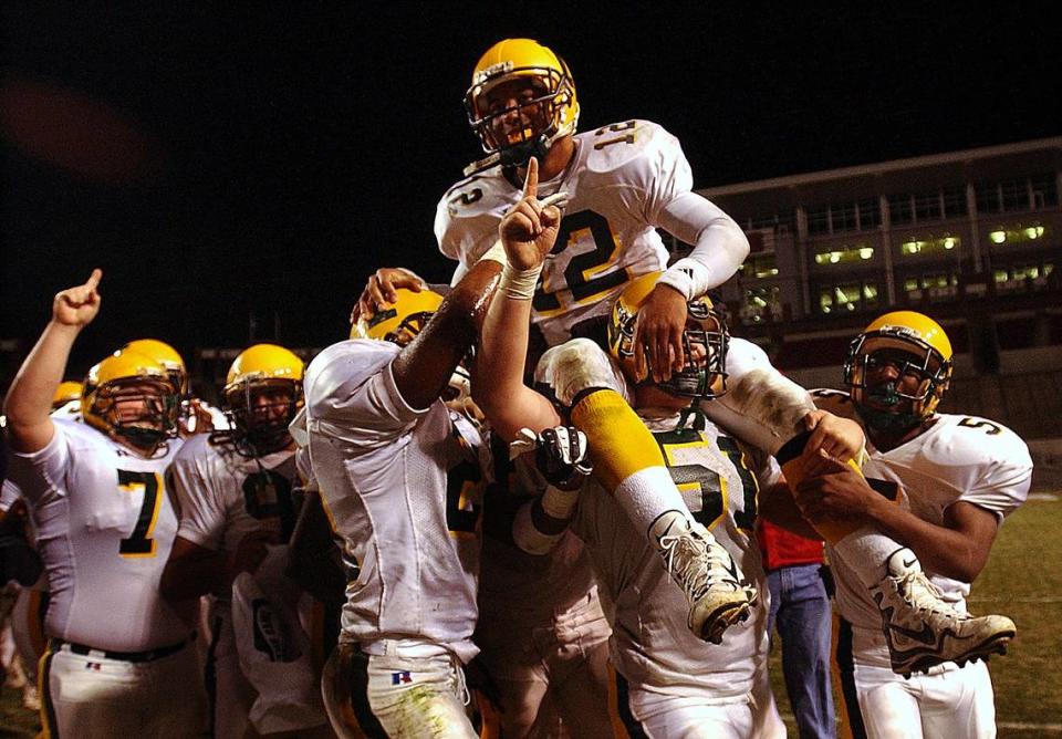 12/14/02: Independence High quarterback (12) Chris Leak is carried atop his teammates shoulders after they defeated New Burn Saturday night. Independence played New Bern in the 4A State Championship game in Raleigh, NC. PATRICK SCHNEIDER/STAFF