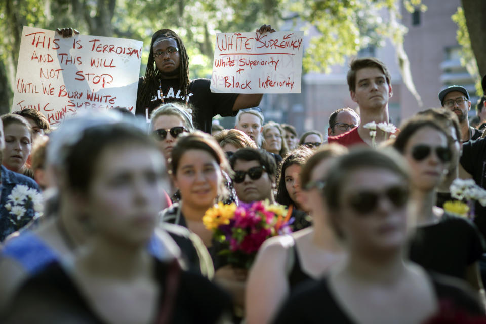 Muhiyidin D'baha holds two signs during a remembrance march in memory of the Emanuel AME Church shooting victims Saturday, June 20, 2015, in Charleston, S.C. (AP Photo/Stephen B. Morton)