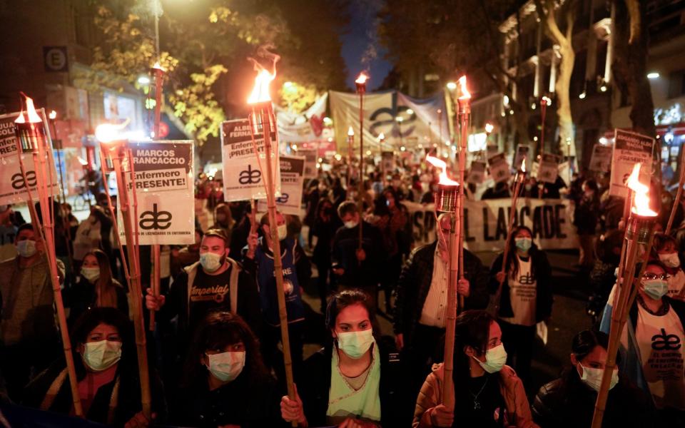 Nurses march with torches to demand increases in their salary, professional recognition, and better working conditions in Buenos Aires - AP