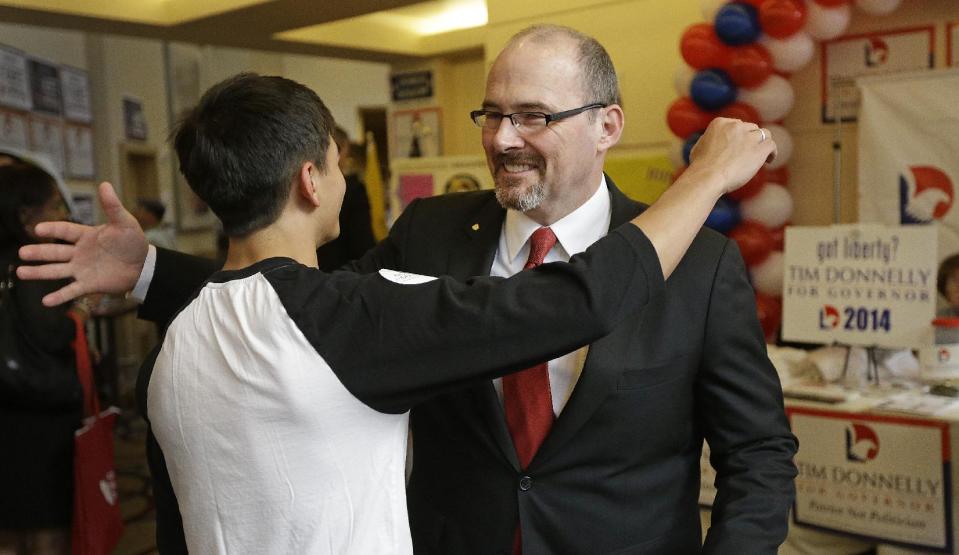 Gubernatorial candidate Tim Donnelly, right, embraces his son, Daniel, at the California Republican Party 2014 Spring Convention in Burlingame, Calif. on Saturday, March 15, 2014. California Republicans are gathering in the San Francisco Bay Area to plan the future of the party in a state where their registration and influence have been sliding. (AP Photo/Ben Margot)