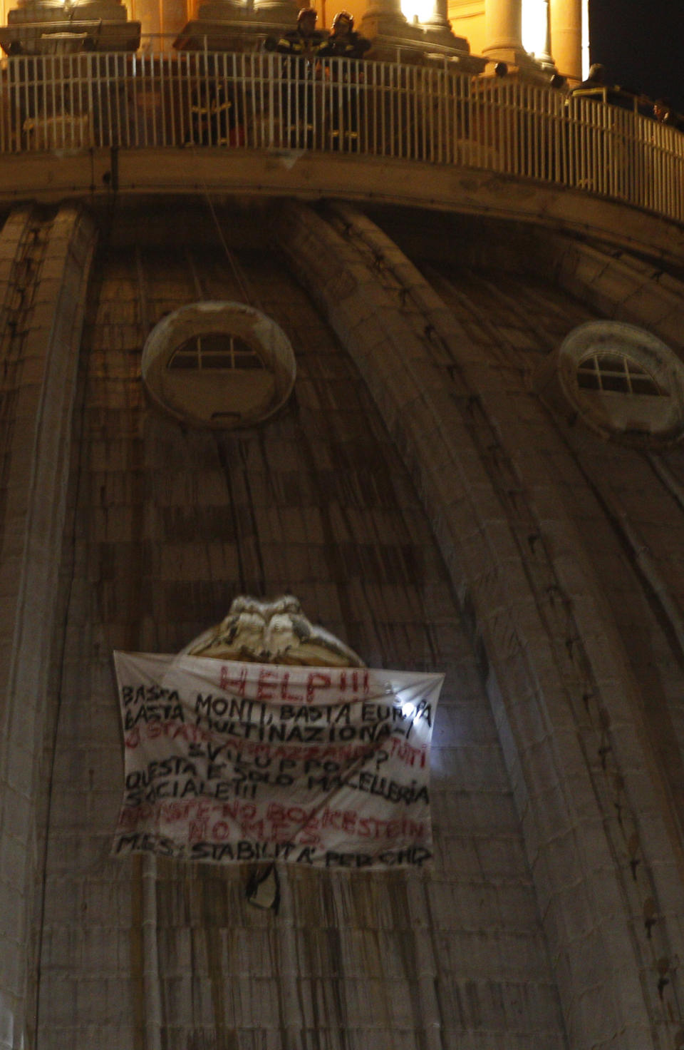 Italian firefighters, top, look at a banner hanging from a window of St. Peter's dome at the Vatican, Tuesday, Oct. 2, 2012. (AP Photo/Alessandra Tarantino)