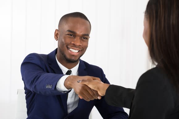 Professional male shaking hands with professional female.