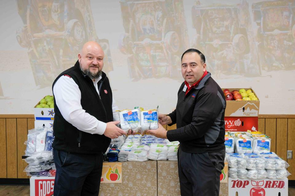 Major Tex Ellis of the Salvation Amry of Amarillo accepts 1,000 pairs of socks as part of the Pears for Pairs program Tuesday from Fernando Noriega, store director for United Supermarkets in Amarillo.
