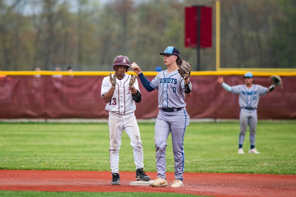 John Jay players react after Arlington's Eric Santaella celebrates being called safe on a steal of second base during an April 30, 2024 baseball game.