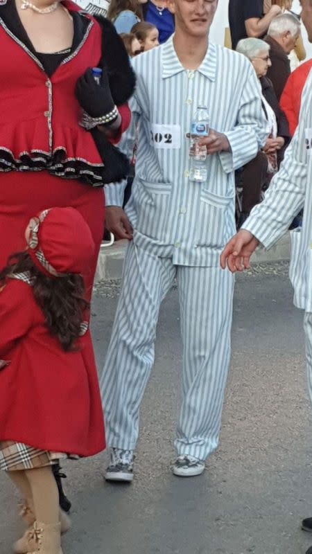 A person disguised as a concentration camp prisoner walks during a carnival parade in Campo De Criptana