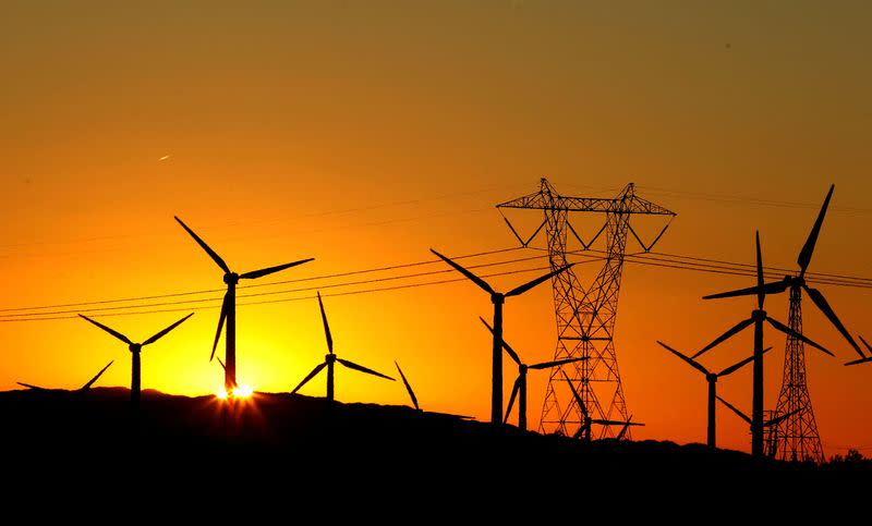 FILE PHOTO: The sun rises behind windmills at a wind farm in Palm Springs