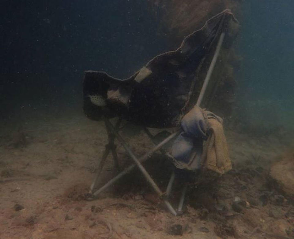 A discarded camp chair underwater.