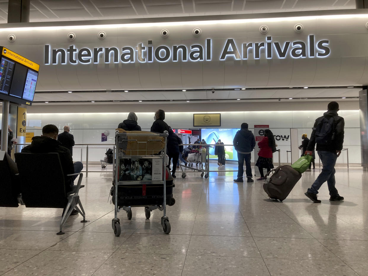 Some people wait and some people arrive in the arrivals area at Heathrow Airport, in London, Monday, Jan. 18, 2021. The UK closed all travel corridors from Monday morning to protect against the coronavirus with travellers entering the country from overseas required to have proof of a negative COVID-19 test. (AP Photo/Matt Dunham)