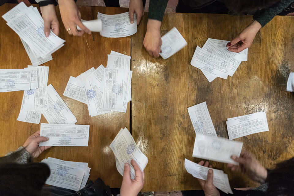 Election officials start counting ballots at the polling station after the second round of presidential elections in Mariinka, Donetsk region, eastern Ukraine, Sunday, April 21, 2019. Ukrainians voted on Sunday in a presidential runoff as the nation's incumbent leader struggles to fend off a strong challenge by a comedian who denounces corruption and plays the role of president in a TV sitcom. (AP Photo/Evgeniy Maloletka)