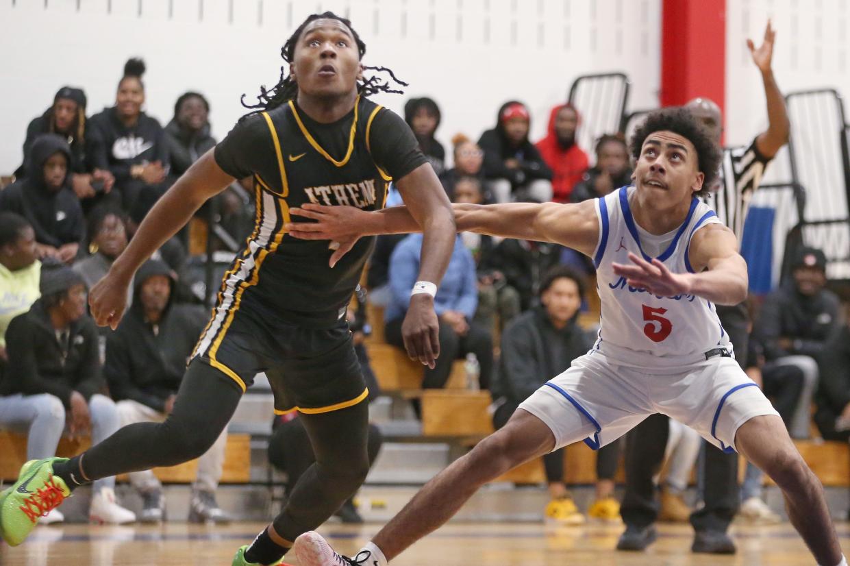 Athena's I'zayah Reaves and Monroe's Marcus Freeman battle for position under the rim on a foul shot in the first quarter.