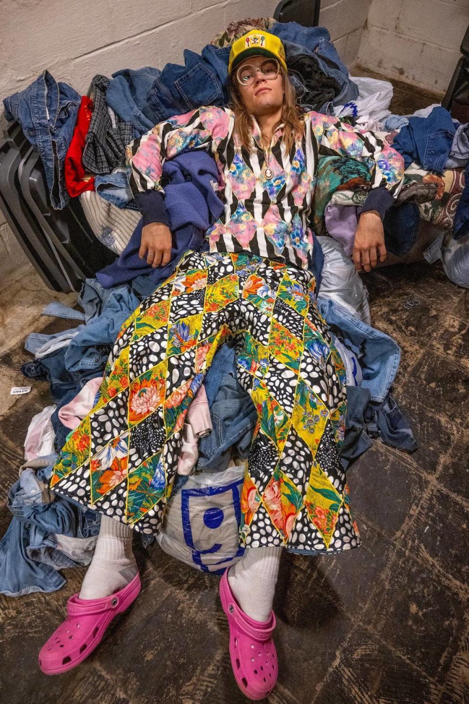 Johnson posed with a supply of denim fabric he keeps at his home to create some of his designs.