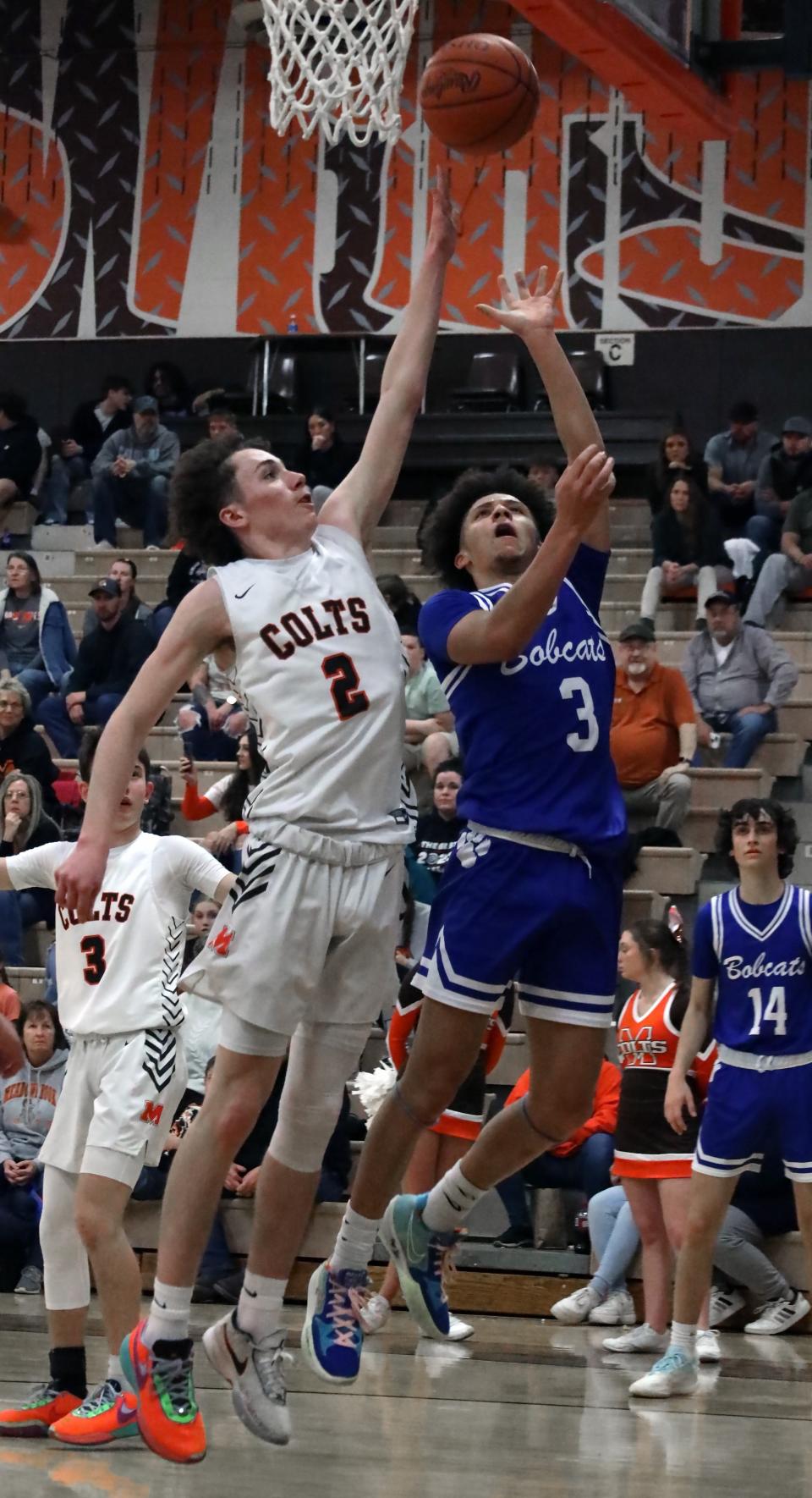 Cambridge's Jesiah Barnett (3) puts up a shot over Meadowbrook's Masyn Campbell (2) during the Colts versus Bobcats basketball game Tuesday evening at Meadowbrook High School.