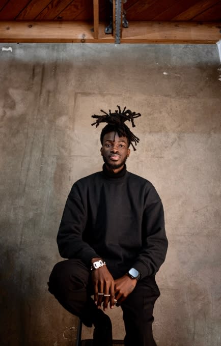 Iddris Sandu sitting in a chair. 