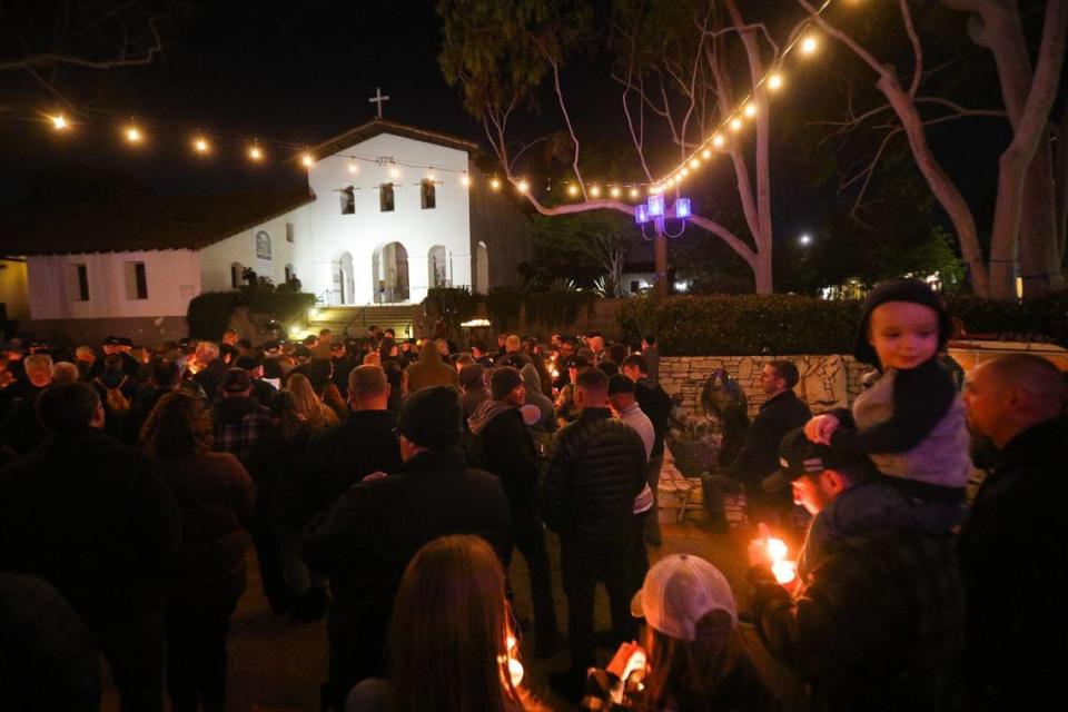 From left front holding candles: Riley, Alycia, Trevor and Noah Aguilar, 3, on his dad’s shoulders, were among more than 200 people who filled Mission Plaza on May 10, 2022, to remember San Luis Obispo police Det. Luca Benedetti. The police officer died in the line of duty one year ago while serving a search warrant.