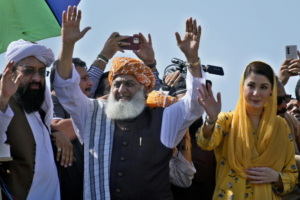 Maulana Fazalur Rehman, center, and Maryam Nawaz, right, leaders of the Pakistan Democratic Alliance, wave to supporters during a protest outside the Supreme Court, in Islamabad, Pakistan, Monday, May 15, 2023. Thousands of Pakistani government supporters converged on the country's Supreme Court, in a rare challenge to the nation's judiciary. Protesters demanded the resignation of the chief justice over ordering the release of former Prime Minister Imran Khan. (AP Photo/Anjum Naveed)