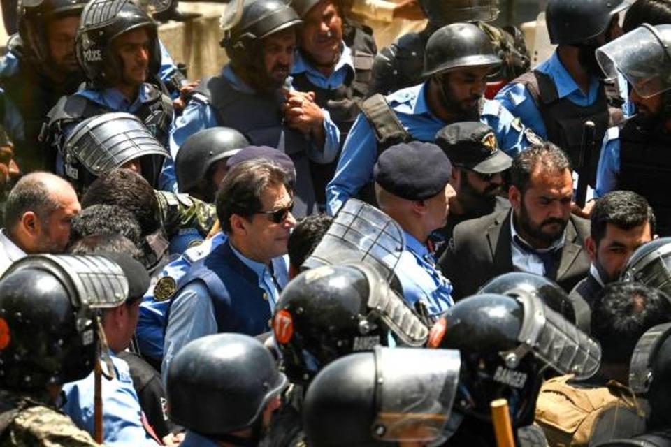 Police escort Pakistan’s former prime minister Imran Khan as he arrives at the high court in Islamabad on 12 May 2023 (AFP via Getty)