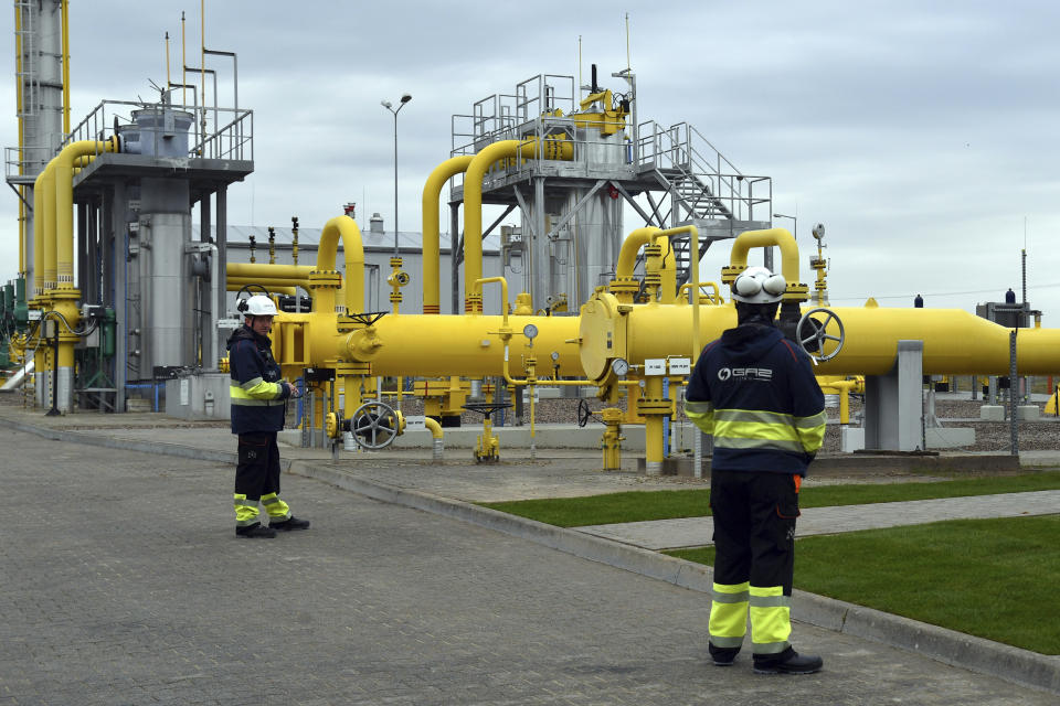 Workers stand near the pipelines during an opening ceremony of the Baltic Pipe in Budno, Poland, Tuesday, Sept. 27, 2022. The event marks the end of the process of the Baltic Pipe construction, a key route to carry gas from Norway through Denmark to Poland and neighboring countries. (AP Photo)