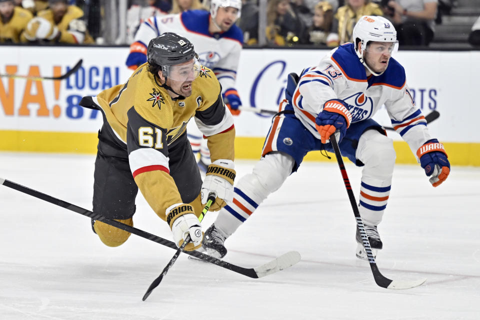 Vegas Golden Knights right wing Mark Stone (61) dives to take a shot against Edmonton Oilers center Mattias Janmark (13) during the second period of an NHL hockey game Tuesday, Feb. 6, 2024, in Las Vegas. (AP Photo/David Becker)