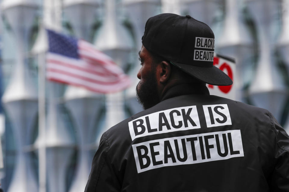 A protester stands in front of the US embassy during the Black Lives Matter protest rally in London, Sunday, June 7, 2020, in response to the recent killing of George Floyd by police officers in Minneapolis, USA, that has led to protests in many countries and across the US. (AP Photo/Frank Augstein)