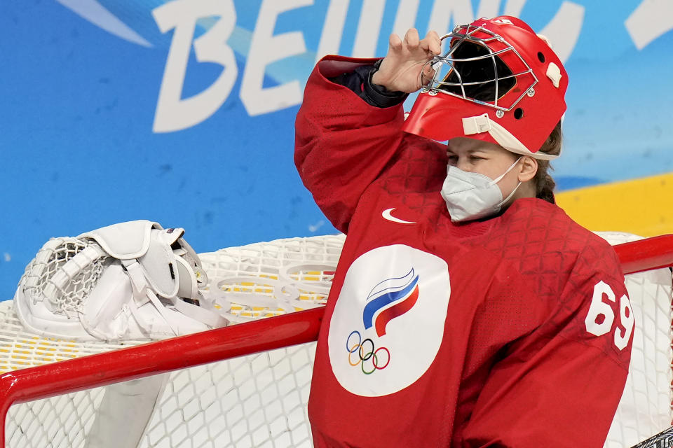 Russian Olympic Committee goalkeeper Maria Sorokina pulls her helmet over a COVID mask during a preliminary round women's hockey game against Canada at the 2022 Winter Olympics, Monday, Feb. 7, 2022, in Beijing. (AP Photo/Petr David Josek)