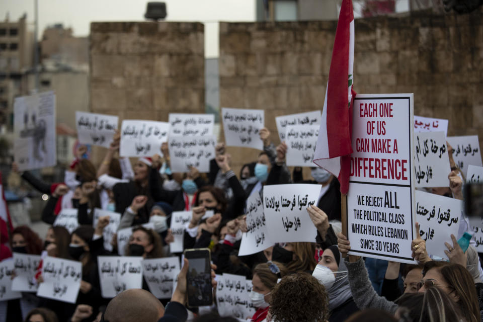 Protesters hold placards as they participate in a march against the political leadership they blame for the economic, financial crisis and 4 Aug. Beirut blast, in Beirut, Lebanon, Saturday, March 20, 2021. (AP Photo/Hassan Ammar)