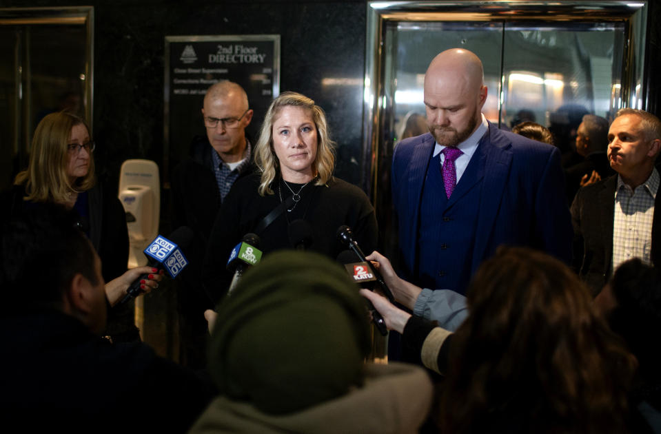 Sarah Stretch, center, and Noah Horst, center right, speaks to reporters after the indictment hearing of Joseph David Emerson on Thurs., Dec. 7, 2023, in Portland, Ore. Stretch is married to Emerson, 44, a pilot who is accused of trying to turn off the engines in flight of a plane he was riding in while off duty, and Horst is Emerson's attorney. (Dave Killen/The Oregonian via AP, Pool)