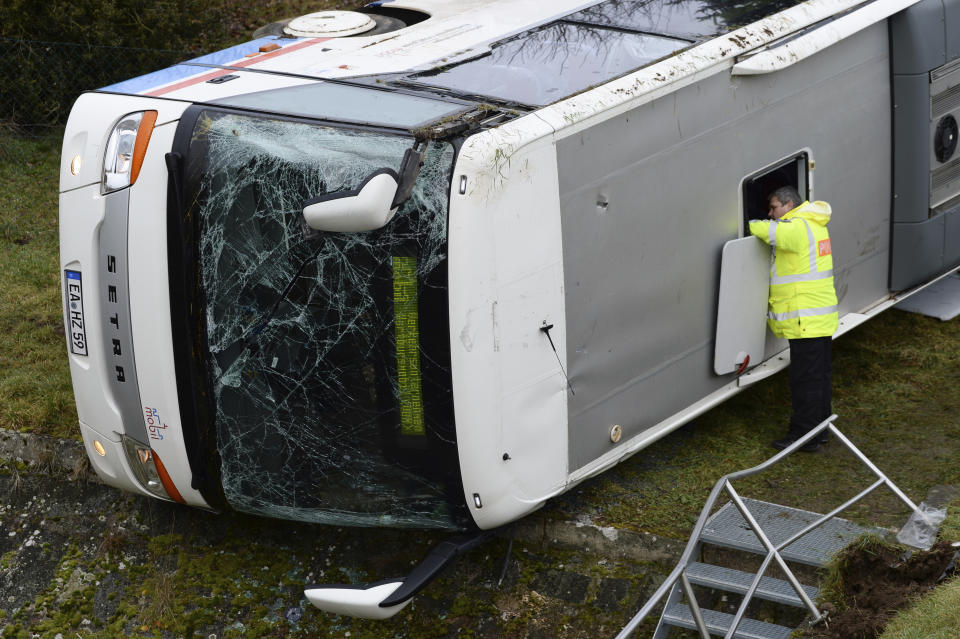 A police office looks into a school bus that has crashed in Berka Vor Dem Hainich, near Eisenach, Germany, Thursday, jan. 23, 2020. German media reported that two children died in a school bus crash in the central state of Thuringia early Thursday. Public broadcaster MDR reported that 20 children and the bus driver were injured in the crash in Berka, about 260 kilometers (160 miles) southwest of Berlin. (Swen Pfoertner/dpa via AP)