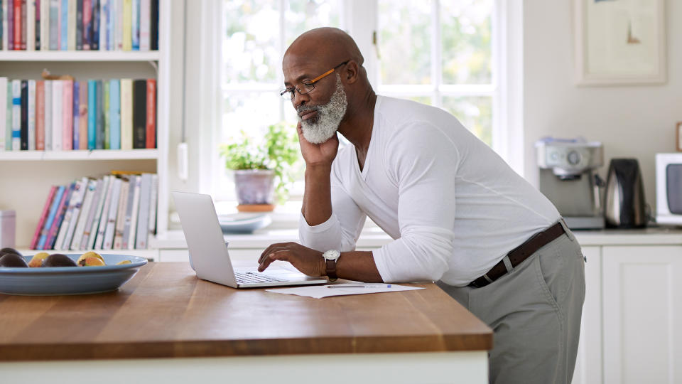 Shot of a mature man using a laptop while working out his retirement plan at home..