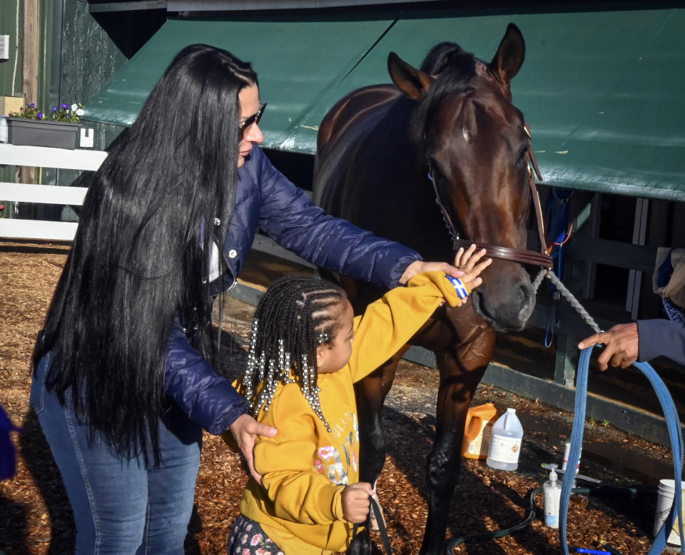 Lovely Brown, 4, meets Preakness contender Simplification with the assistance of the horse's owner Tami Bobo, Tuesday, May 17, 2022 at Pimlico Race Course in Baltimore. The Preakness Stakes horse race is schedule to run Saturday, May 21. (Jerry Jackson/The Baltimore Sun via AP)