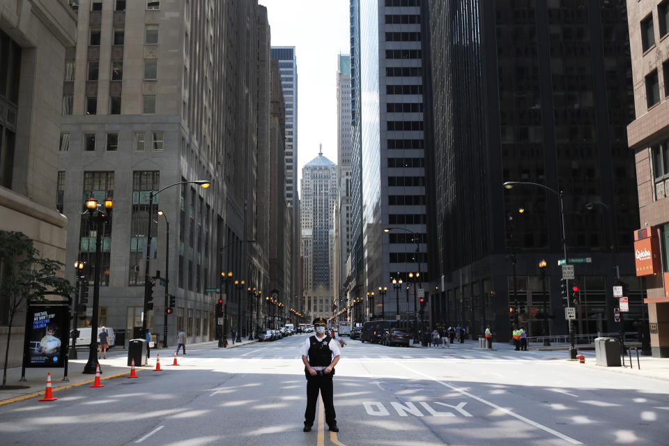 FILE - In this June 17, 2020, file photo a Chicago police officer stands alone on La Salle Street as he waits for protesters to continue their march calling on Mayor Lori Lightfoot to enact an ordinance for an all-elected Civilian Police Accountability Council, CPAC. (AP Photo/Charles Rex Arbogast, File)