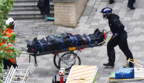 <p>Emergency workers wheel away a body from the fire-gutted Grenfell Tower in London, Friday, June 16, 2017, after a fire engulfed the 24-story building Wednesday morning. (Photo: Rick Findler/PA via AP) </p>