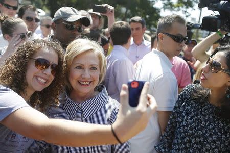 United States Democratic presidential candidate Hillary Clinton poses for a photo with a woman at the Iowa State Fair in Des Moines, Iowa August 15, 2015. REUTERS/Joshua Lott