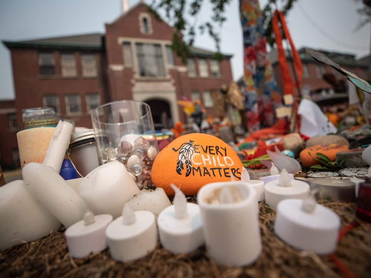 A memorial outside the former Kamloops Indian Residential School, in Kamloops, B.C., in July. About 200 possible unmarked burial sites were detected by a radar survey this past spring at the site. (Darryl Dyck/The Canadian Press - image credit)