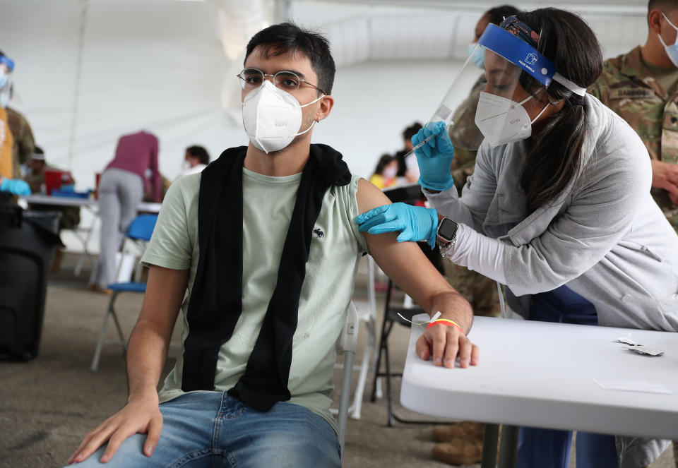 A health care worker immunizes Juan Guevara 